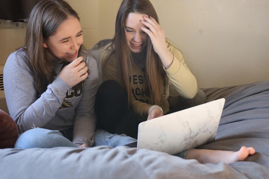 Photo of two students in their room studying