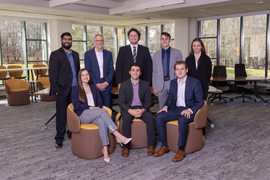 7 students and Dr. Tim Palmer wear business professional outfits are the Haworth College of Business.