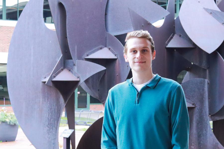 Craig Ferry is wearing a turquoise sweater, outside of the Haworth College of Business.