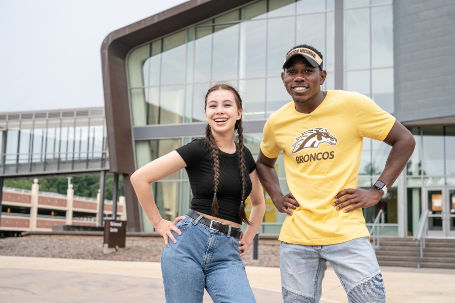 Admissions leaders smiling on main campus near the fountains.