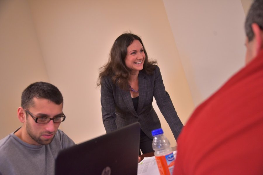Professor chatting with students in class.