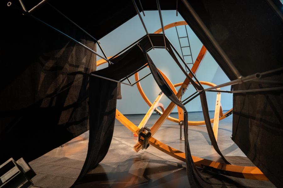 A large wooden sculpture in an art gallery.