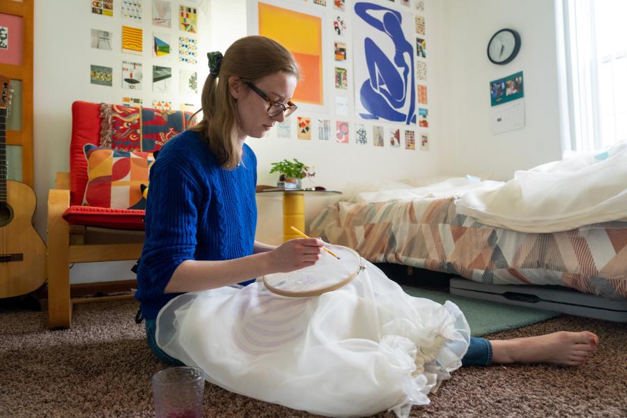 Julia LeKander paints designs on a skirt.