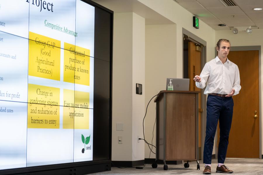 Joshua VanSlambrouck gives a presentation at the front of a room.