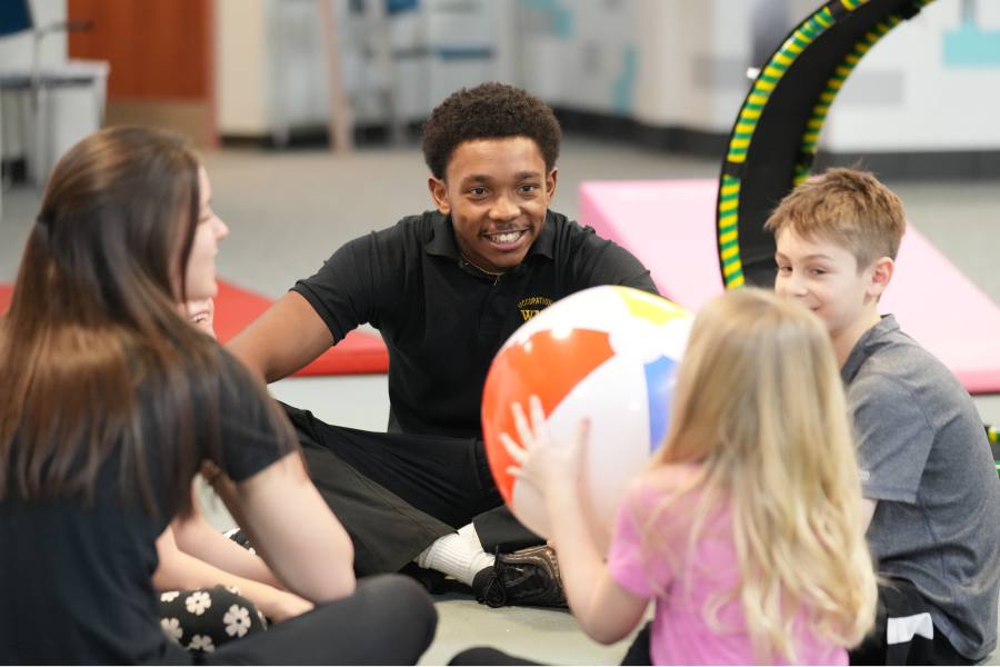 Student-led OT session with three children