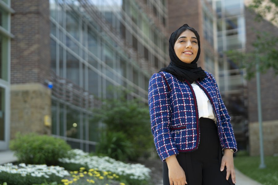A student standing outside the College of Health and Human Services.
