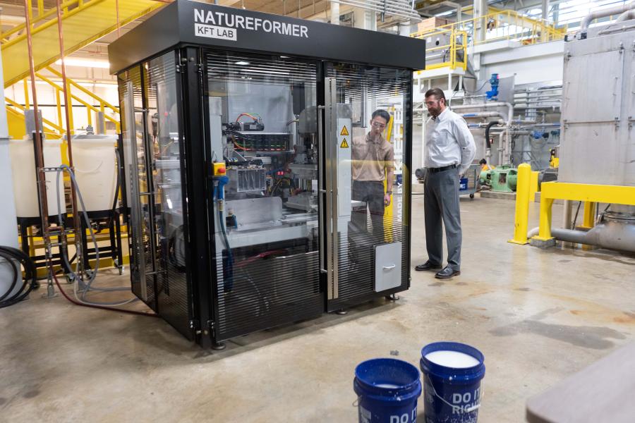 Jason Wang and Lon Pschigoda by a machine at the WMU Pilot Plant