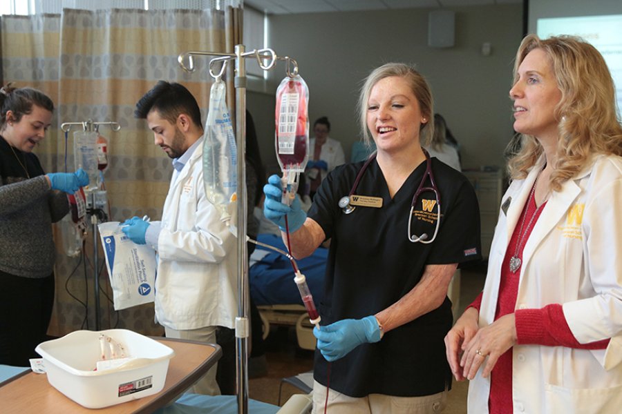 Nursing students practicing with IV bags