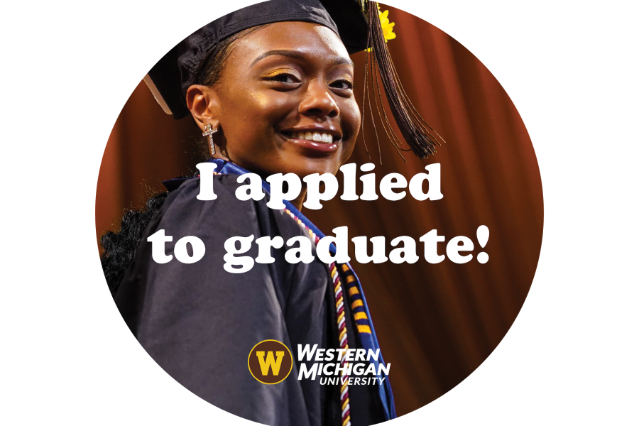 A smiling graduate onstage during a commencement ceremony