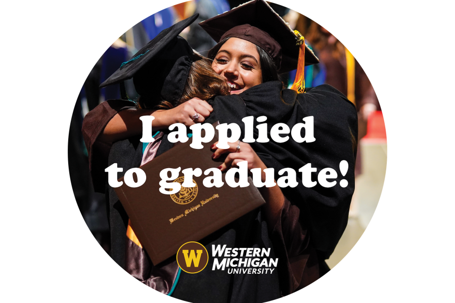 Two graduates hugging onstage during a commencement ceremony
