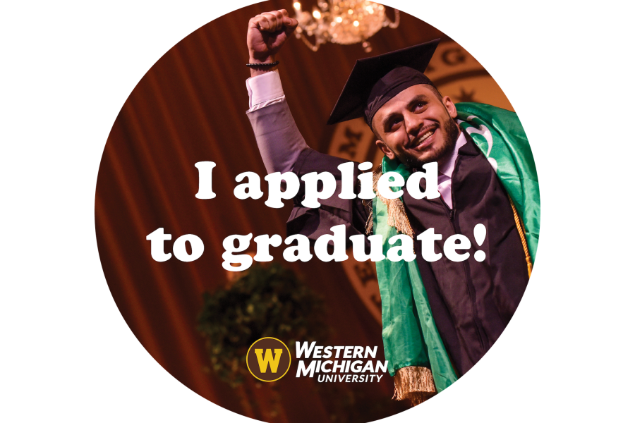 A graduate smiling with their fist in the air