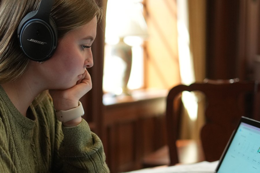 Student attentive to device in library