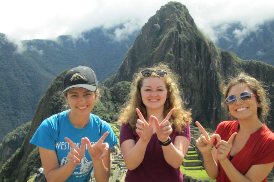 Three WMU students holding up "W" sign while on study abroad