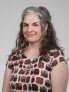 Jennifer Townsend wearing a dress with owls all over it, smiling.