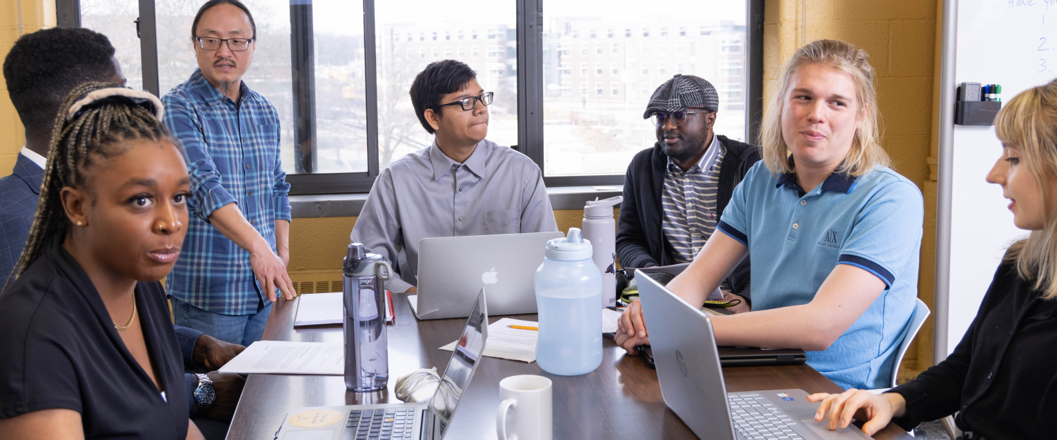 Students sit around a table in the Evaluation Lab.