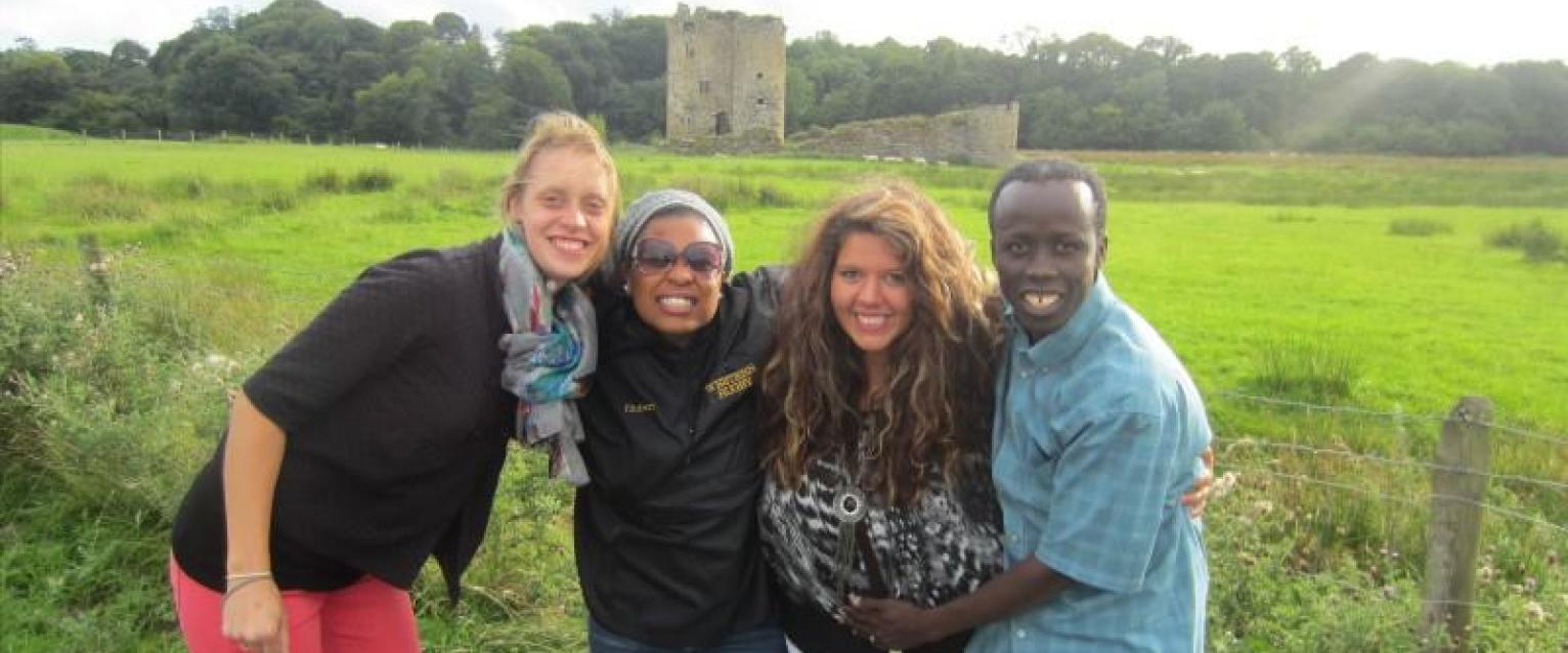 4 students standing in front of a run down castle