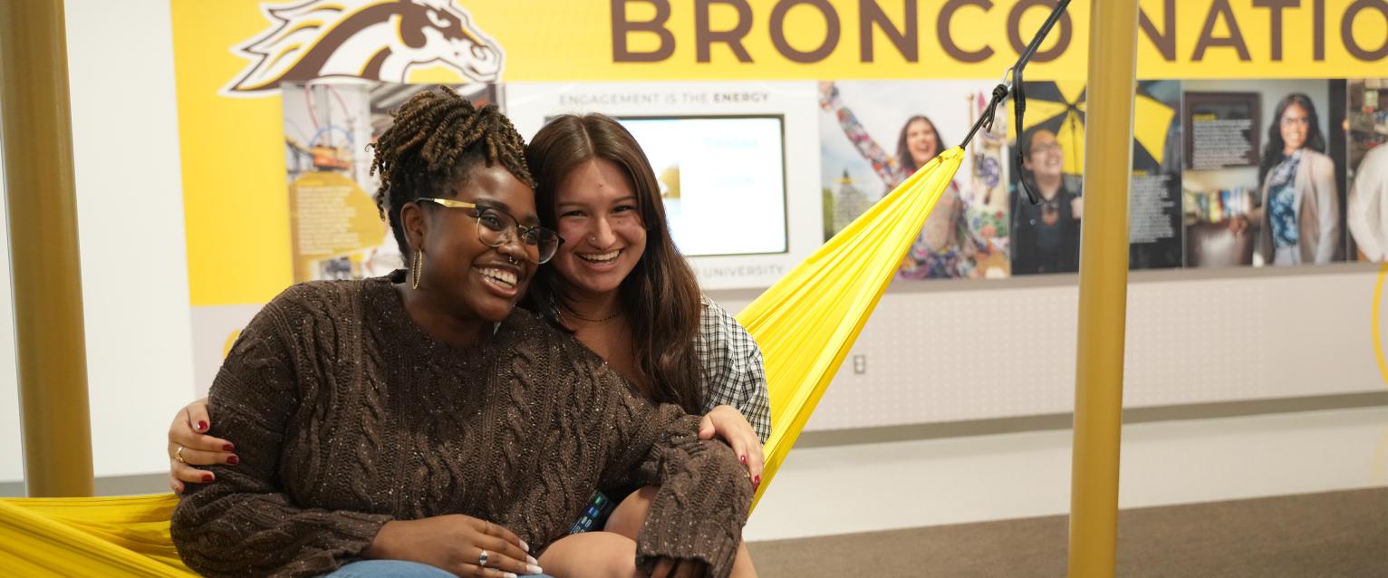 Two students sitting in a hammock in the WMU Student Center.