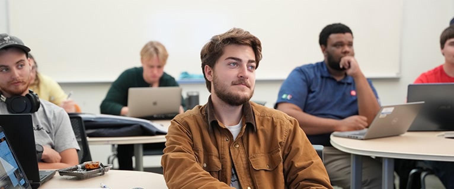 Student in a small class listening to the instructor. 