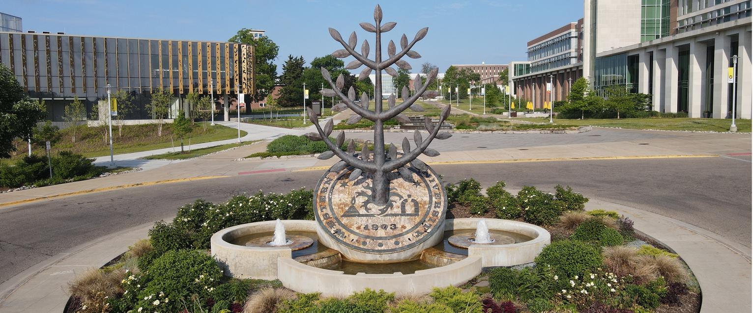 Photo of the WMU seal sculpture in front of the new student center on asunny day
