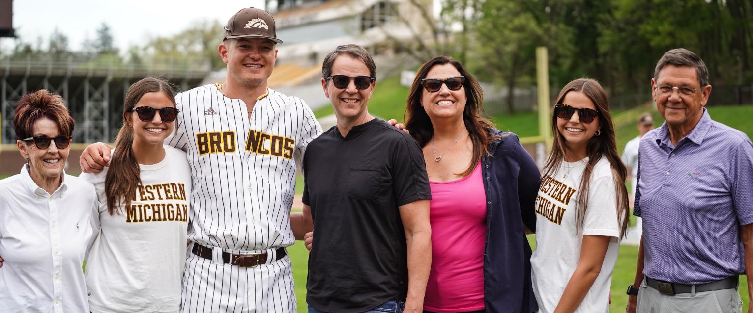 A WMU baseball player and his family on the field.