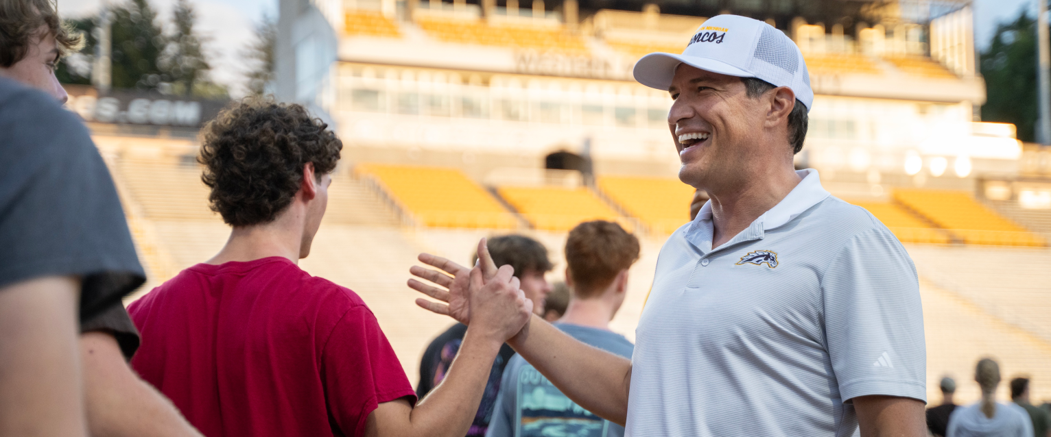 President Russ Kavalhuna high fives a student.