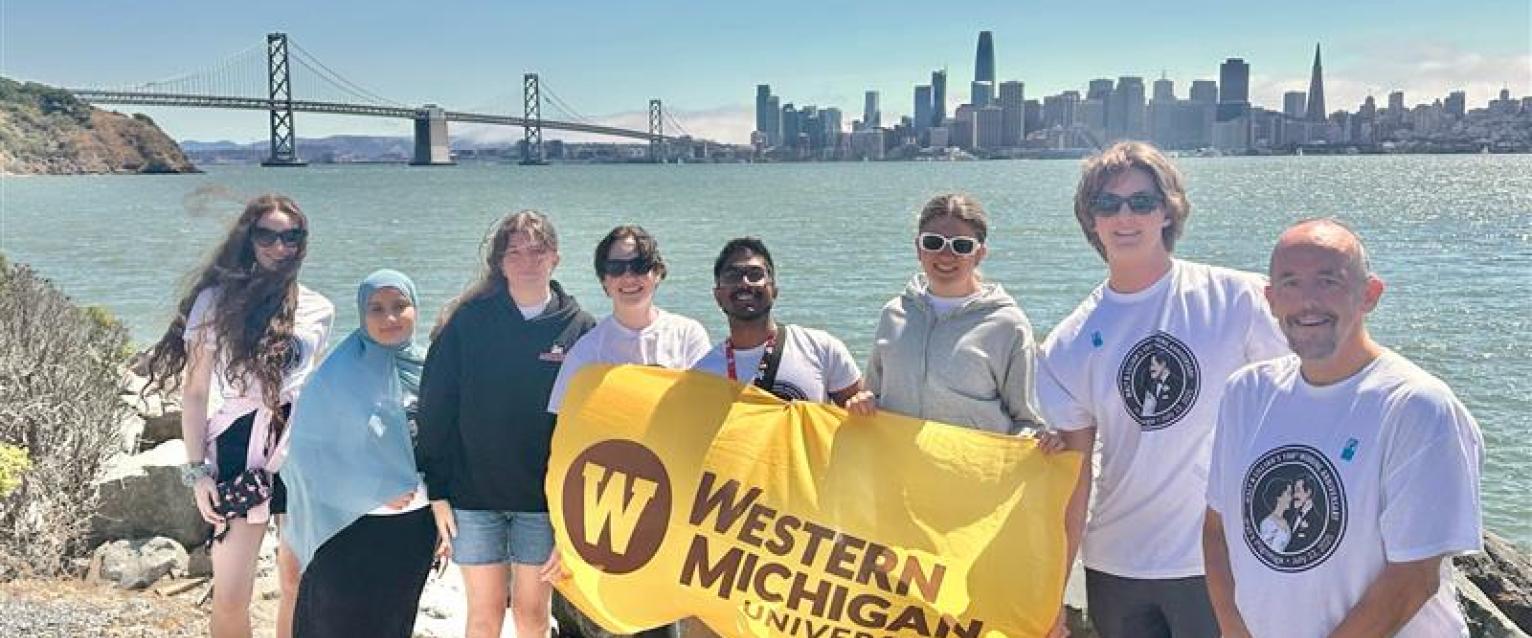 Walt's Pilgrimage students hold a WMU flag in front of the Golden Gate Bridge.