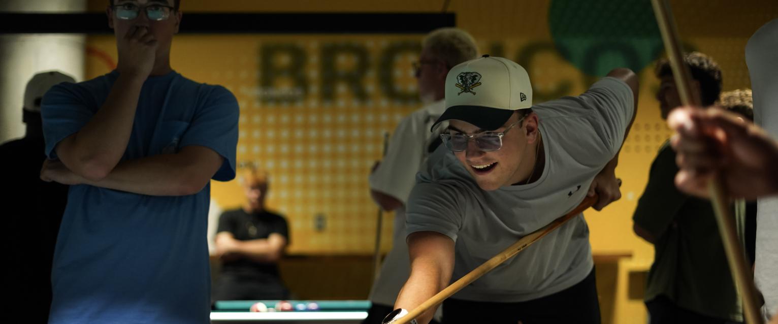 Student playing pool in the game room
