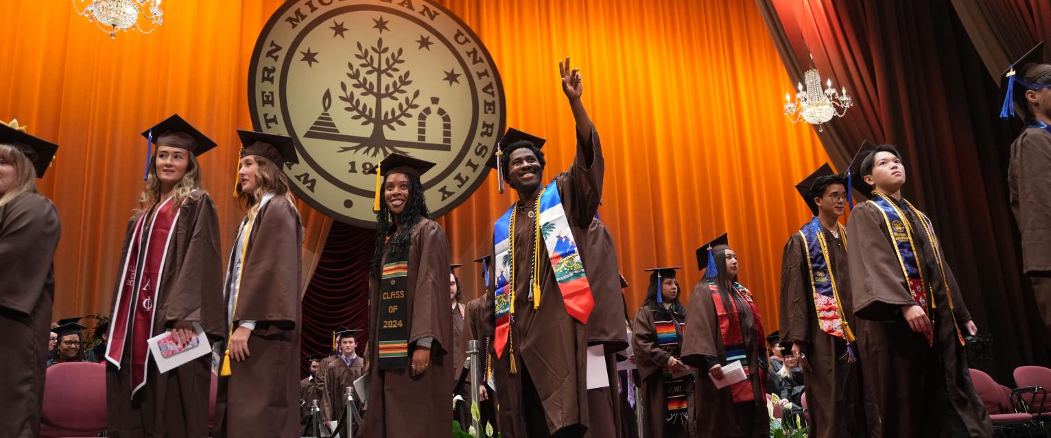 A number of students walking across the stage at a WMU graduation ceremony