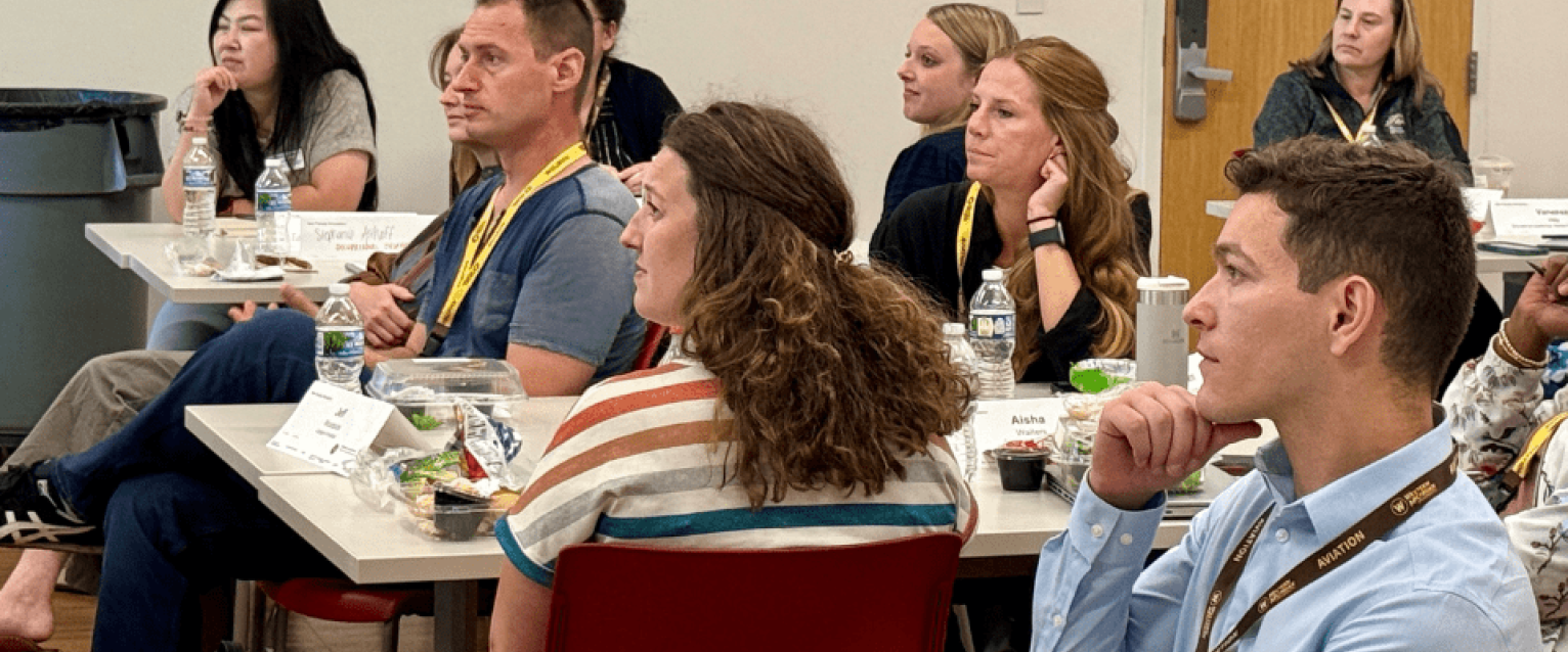 A group of new faculty members listening to a presentation