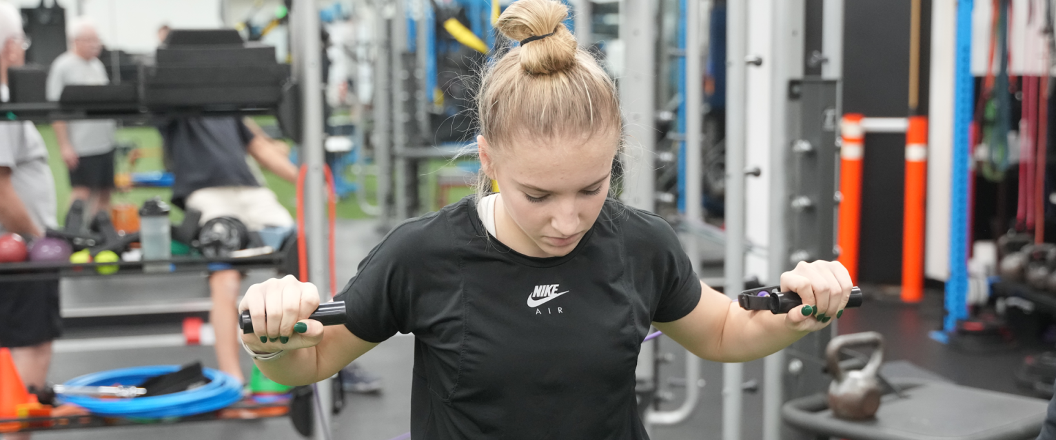 Girl pushing up on a weight machine