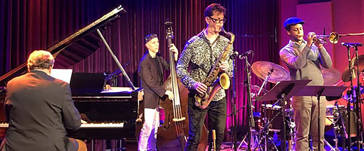 four jazz musicians performing on stage