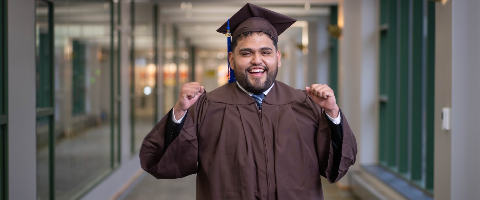 Jesus Osvaldo Martinez-Jimenez, B.B.A.'25, in his cap and gown in Schneider Hall.