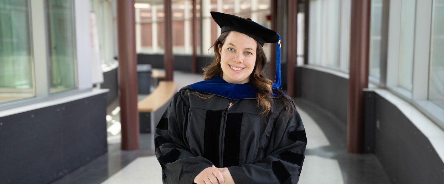 Margaret Mooney, B.S.E.’18, Ph.D.’25, in her cap and gown at Floyd Hall.