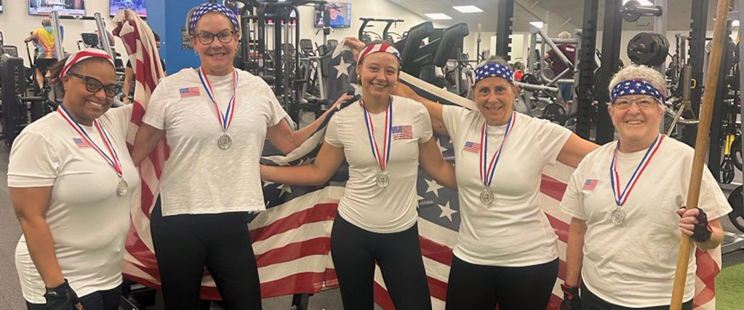 Five ladies dress in USA tshirts and wrapped in a flag