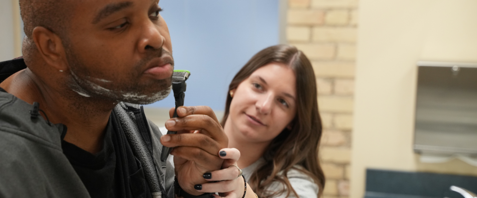 Ot student showing a man how to shave