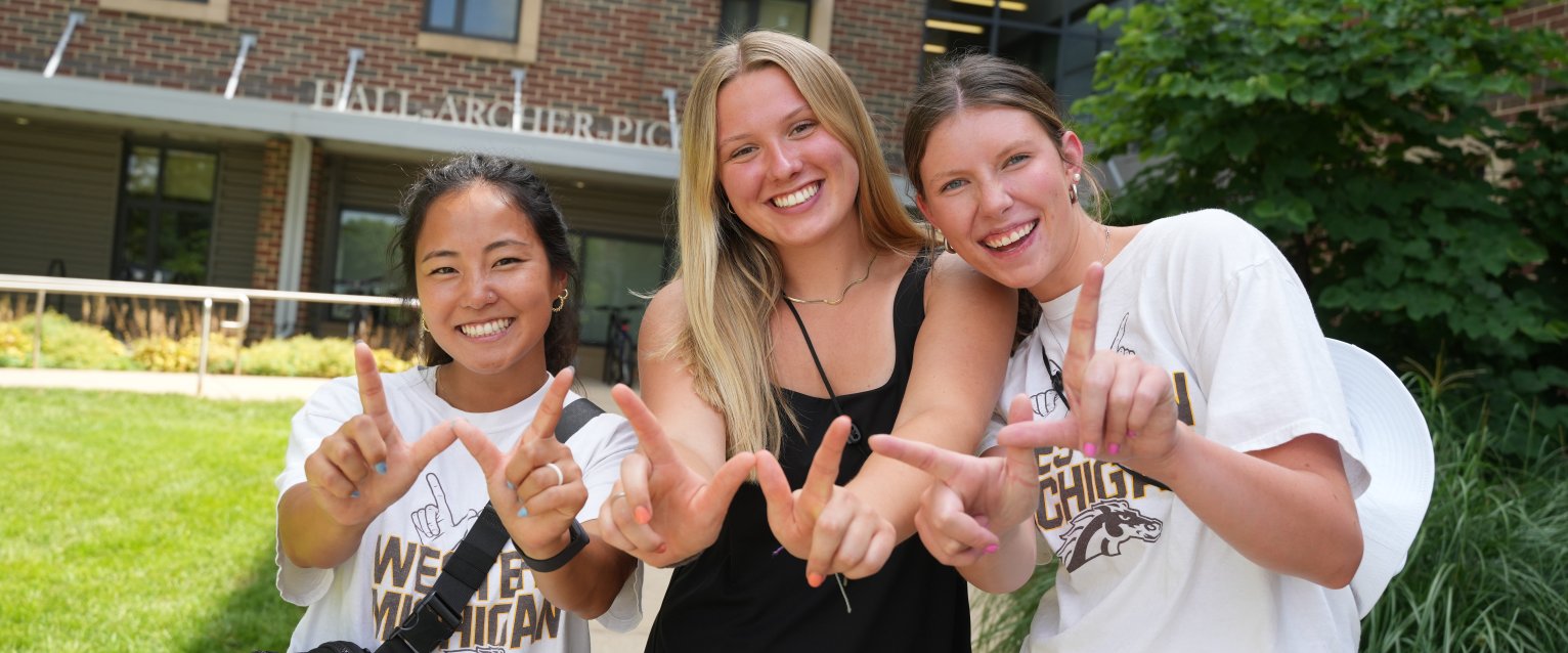 Three WMU students posing outside of Hall-Archer-Pickard residence hall