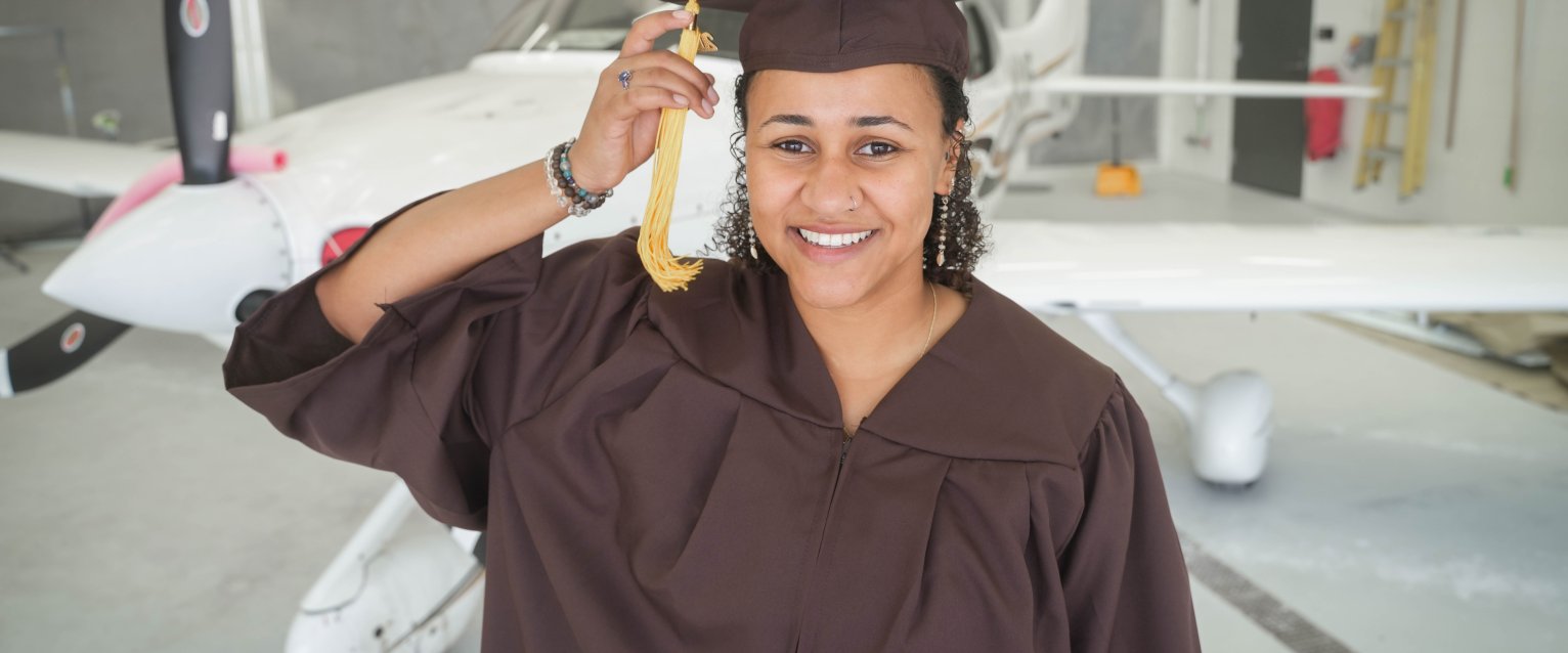 Student standing in fron tof Cirrus plane