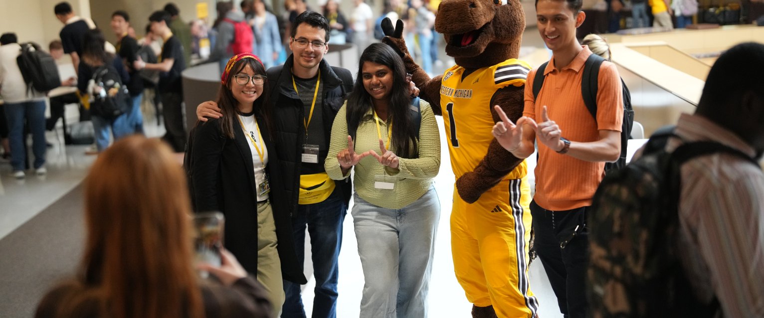 International students making W hands with Buster Bronco at orientation
