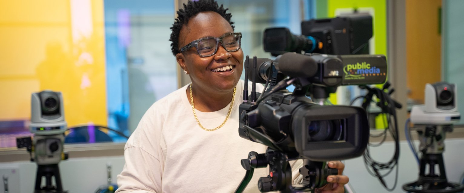 Broncos Lead intern Janay Brown stands behind a camera.
