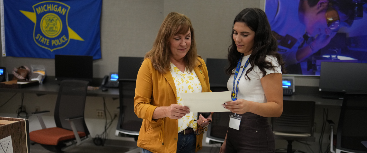 Dr. Ashlyn Kuersten looks at a document with a student in the Cold Case Lab.