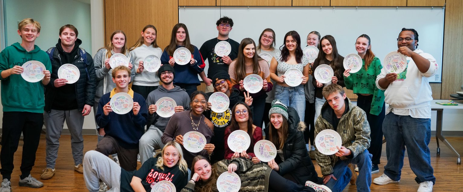 Class photo of WMU First-Year Experience class, students holding paper plates for activity they participated in.
