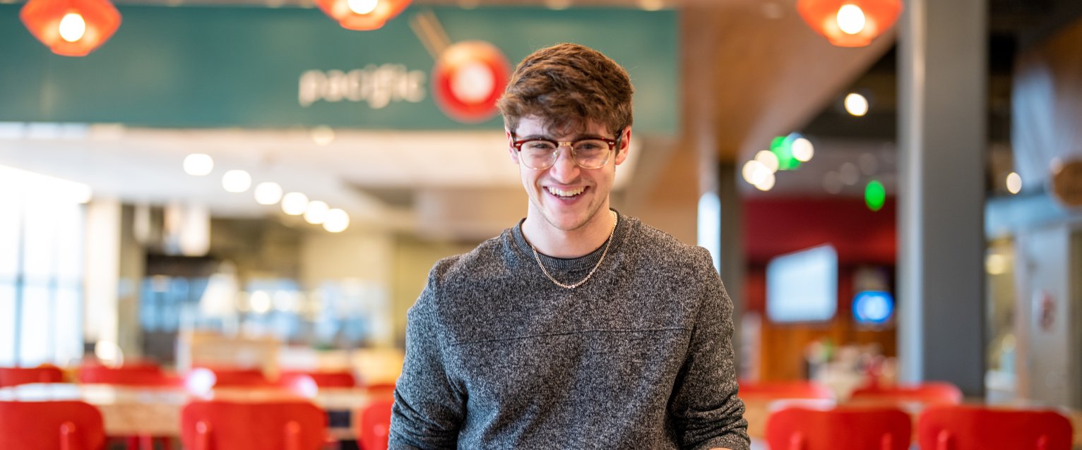 A student carrying a beverage and a plate of food near the Pacific Plate venue at the Valley Dining Center.