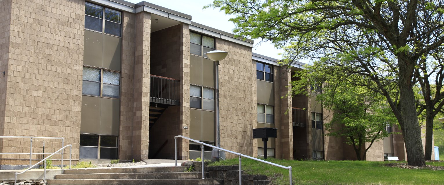 A two-story tan brick apartment building.