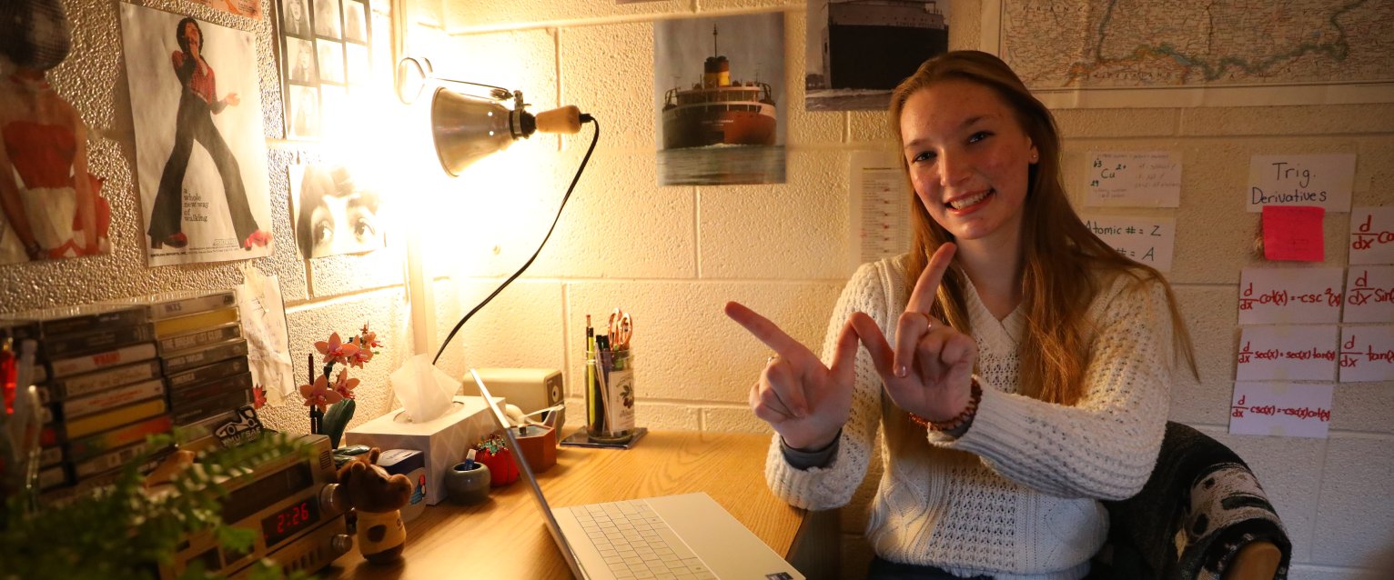 A student sitting at their desk in a decorated residence hall room