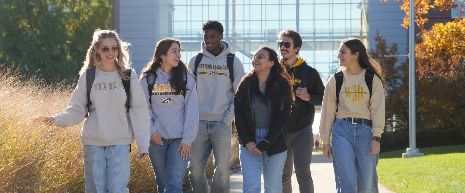A group of WMU students walking and talking on Main Campus.