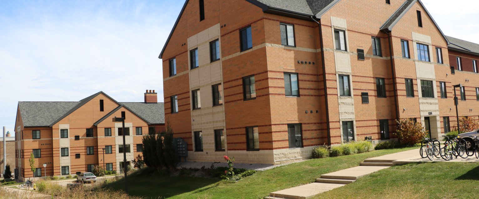 Two modern orange brick apartment buildings in the Western View apartment complex.