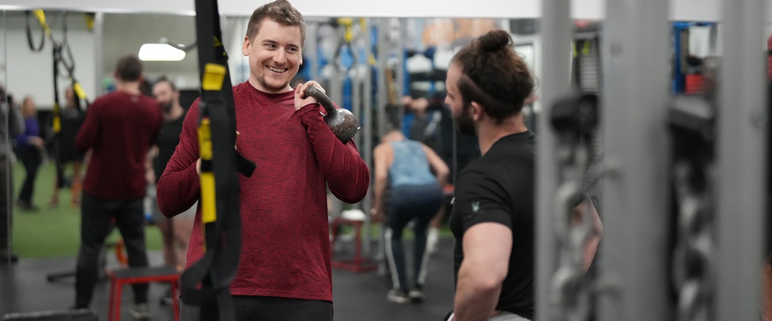 Personal trainer working with a participant with a kettle bell