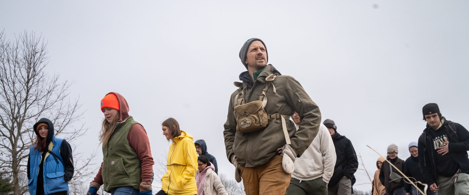 a group of people are seen walking in a grassy field