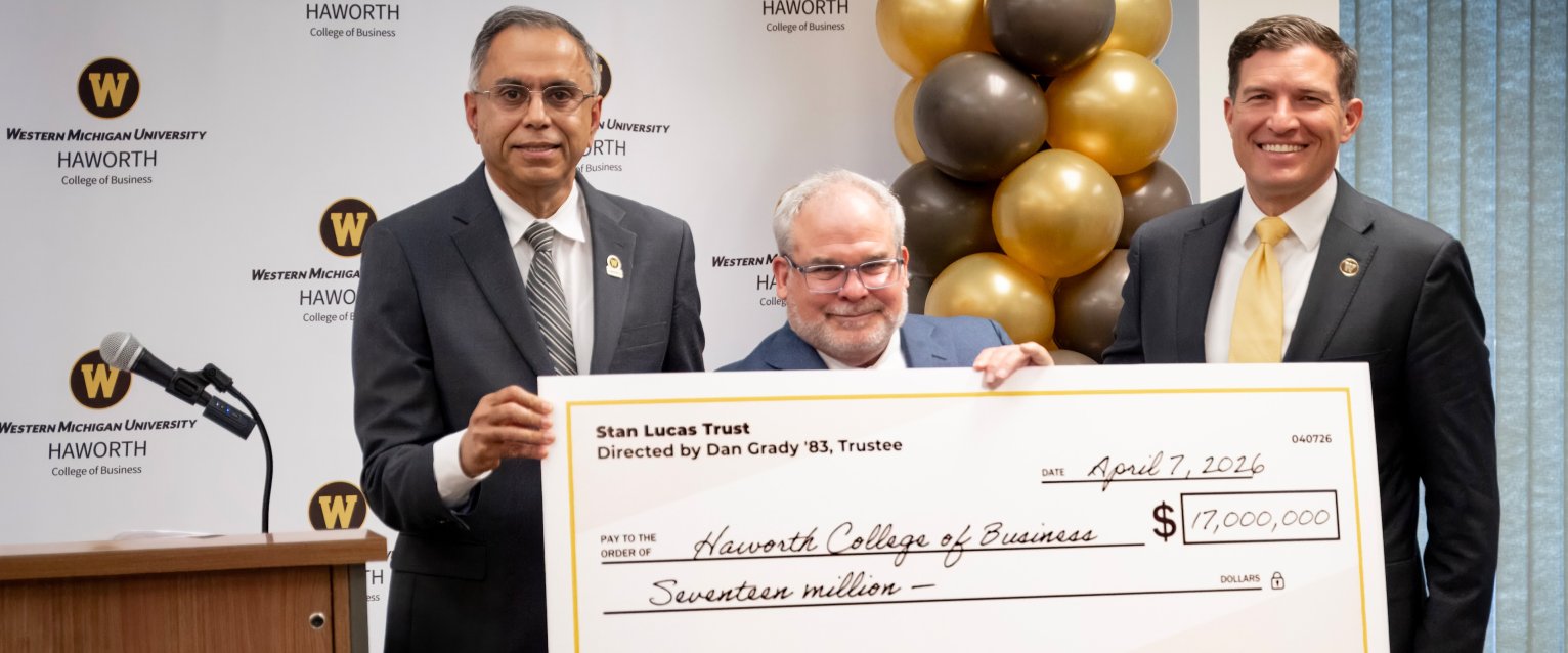 Dr. Satish Desphande, dean of the Haworth College of Business, and WMU President Russ Kavalhuna accept a giant check for $17 million from alumnus Dan Grady on behalf of The Stan Lucas Trust.
