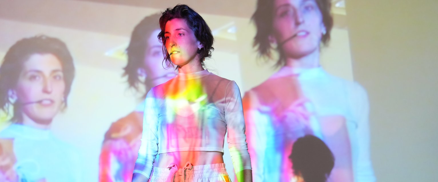 Jess Tucker during performance with projections of the work in front and behind.